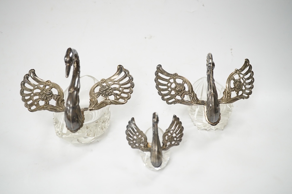 A graduated set of three silver mounted glass swan condiments, London, 1978, largest height 12.9cm. Condition - fair